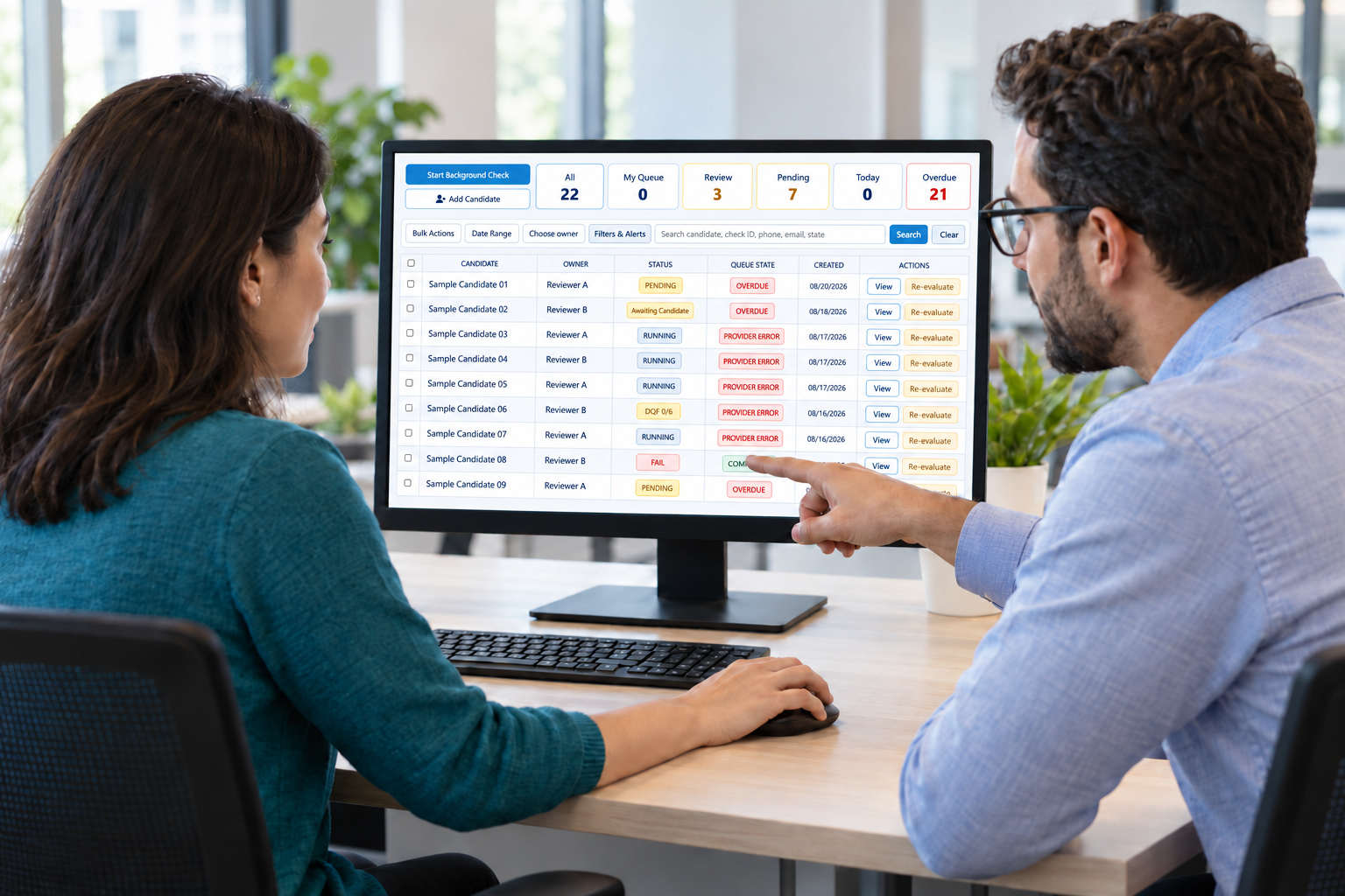 Illustrative workplace scene of two colleagues reviewing an IDC screening queue with fictional sample candidates on a shared monitor
